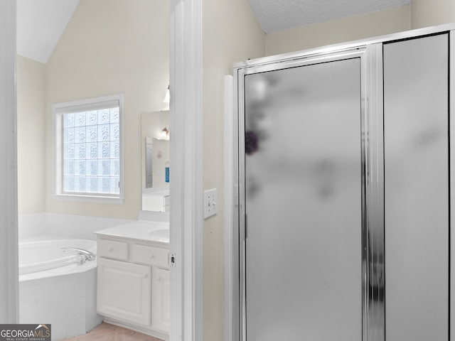 bathroom with vanity, lofted ceiling, independent shower and bath, and a textured ceiling