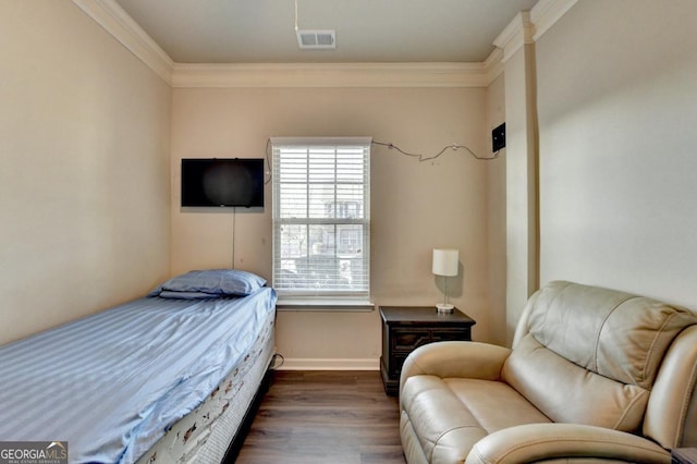 bedroom featuring crown molding and dark hardwood / wood-style flooring