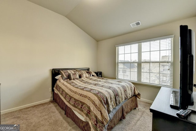 bedroom with lofted ceiling and light carpet