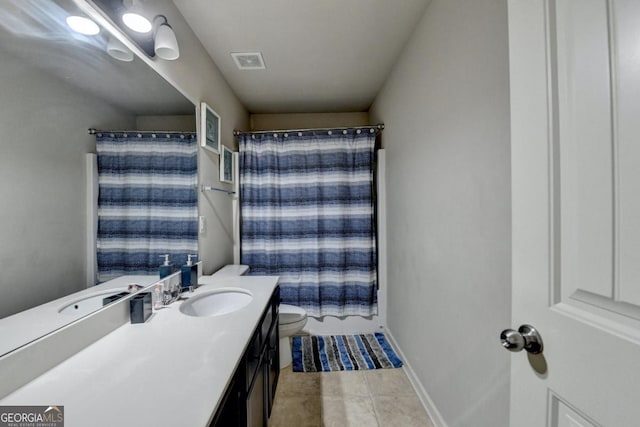 bathroom featuring vanity, tile patterned flooring, and toilet