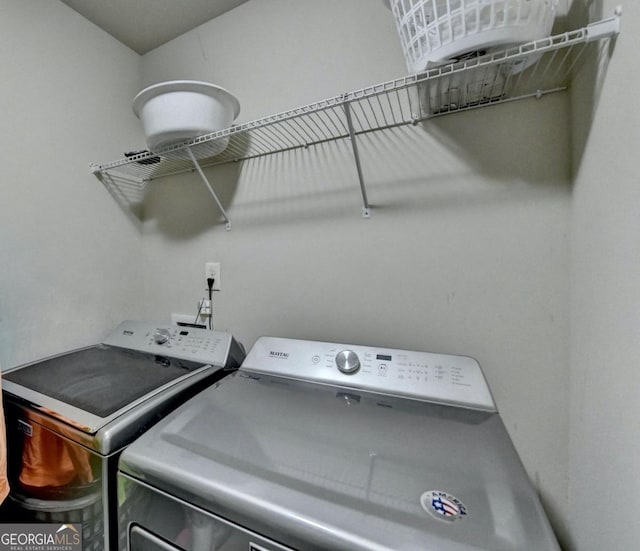 clothes washing area with separate washer and dryer