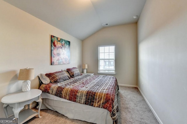 bedroom featuring lofted ceiling and light carpet