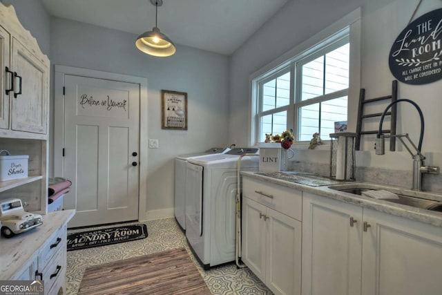 washroom with cabinets, sink, and independent washer and dryer