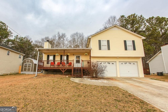 view of front of property featuring a porch, a garage, a front lawn, and a storage shed