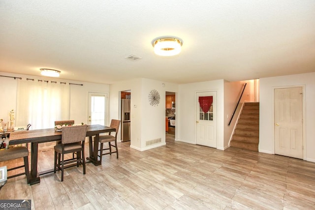 dining area featuring light hardwood / wood-style floors and a textured ceiling