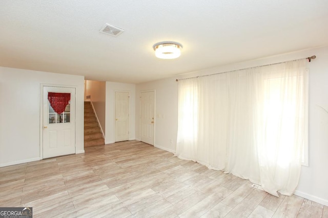 spare room with light hardwood / wood-style flooring and plenty of natural light