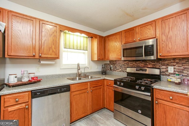 kitchen featuring sink, backsplash, light hardwood / wood-style flooring, and stainless steel appliances