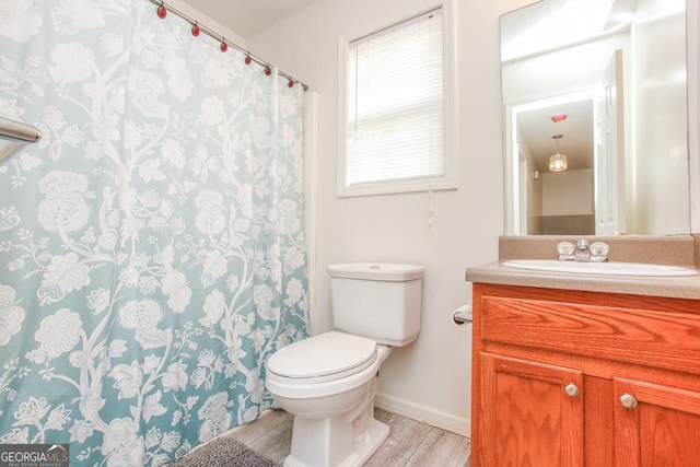 bathroom with wood-type flooring, toilet, and vanity