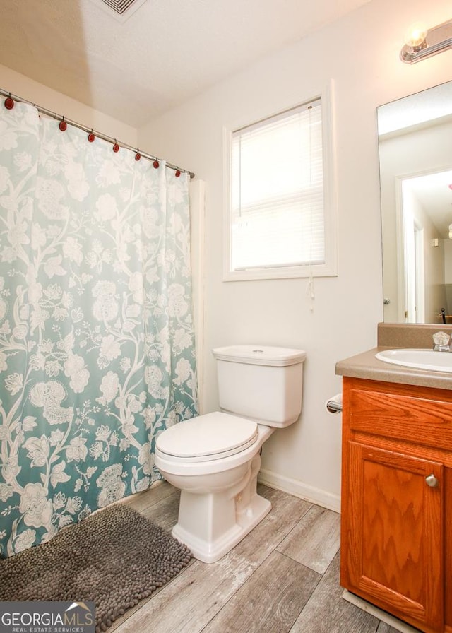 bathroom with vanity, hardwood / wood-style flooring, and toilet