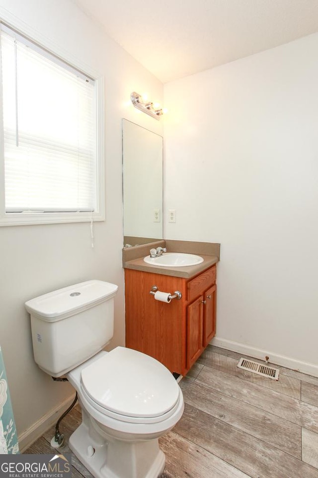 bathroom featuring hardwood / wood-style flooring, vanity, and toilet