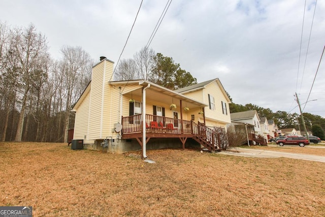 view of front facade featuring central AC, a porch, and a front yard