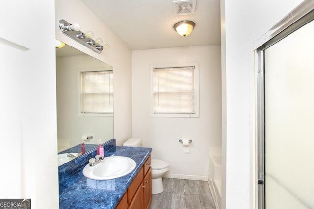 bathroom with vanity, a bath, a textured ceiling, and toilet