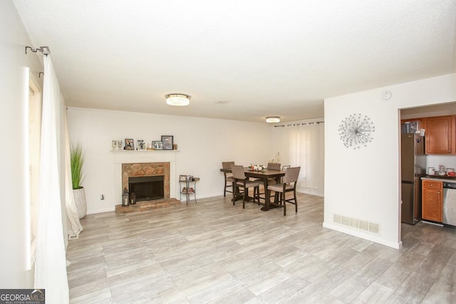 dining room featuring a fireplace and light hardwood / wood-style floors