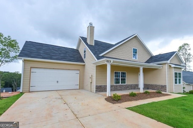 view of front of house featuring a garage, a front yard, and a porch