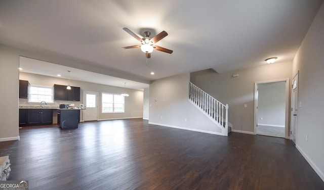 unfurnished living room featuring dark hardwood / wood-style floors, sink, and ceiling fan