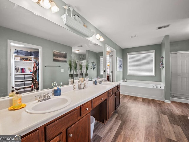 bathroom featuring vanity, shower with separate bathtub, and hardwood / wood-style floors