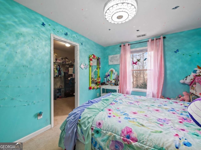 bedroom with a walk in closet, a closet, and carpet flooring