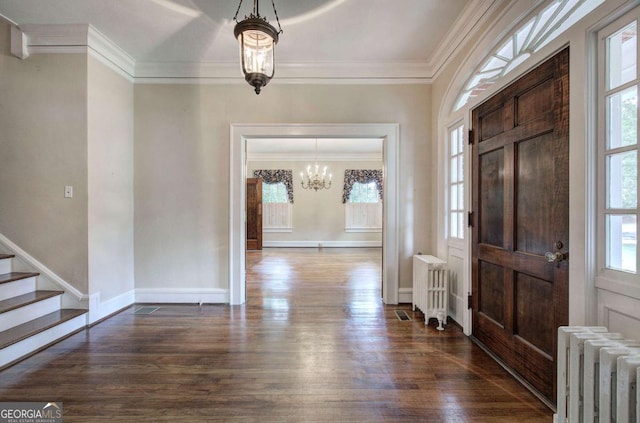 entryway with dark hardwood / wood-style flooring, a notable chandelier, crown molding, and radiator heating unit