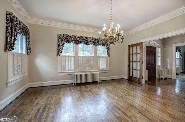 unfurnished room featuring radiator, hardwood / wood-style flooring, and a healthy amount of sunlight