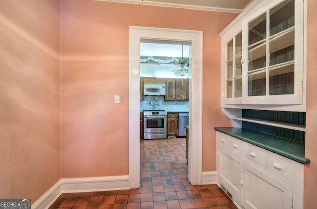 kitchen with white cabinetry, appliances with stainless steel finishes, and dark tile patterned flooring