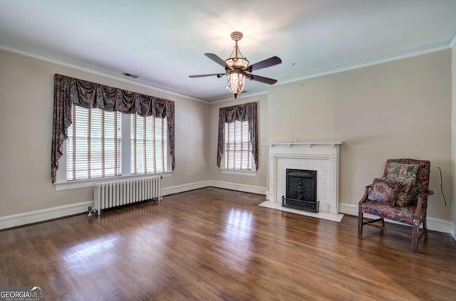 unfurnished living room with a brick fireplace, crown molding, radiator heating unit, and dark wood-type flooring