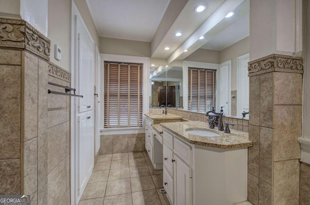 bathroom with tile patterned flooring, vanity, and tile walls