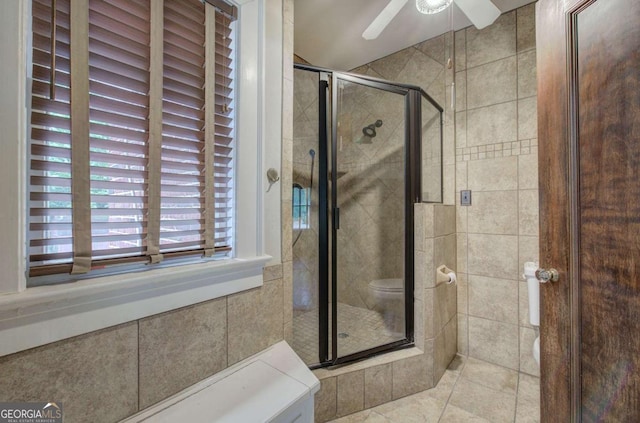 bathroom with ceiling fan and a shower with shower door