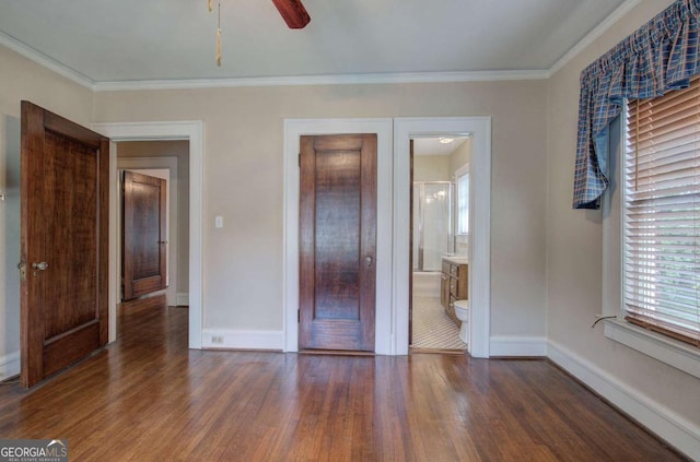 unfurnished bedroom featuring crown molding, ensuite bath, and dark hardwood / wood-style floors