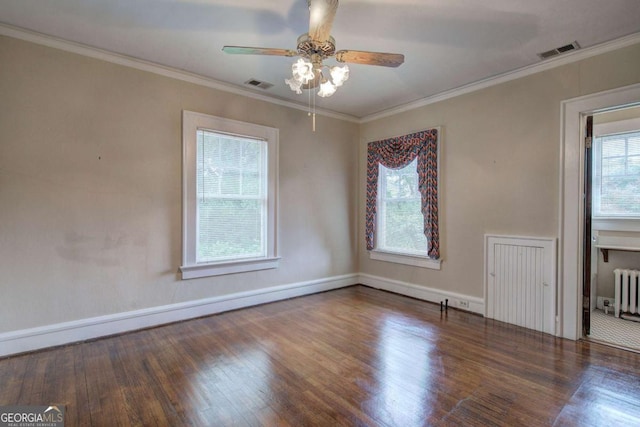 empty room with ornamental molding, radiator, ceiling fan, and dark hardwood / wood-style flooring