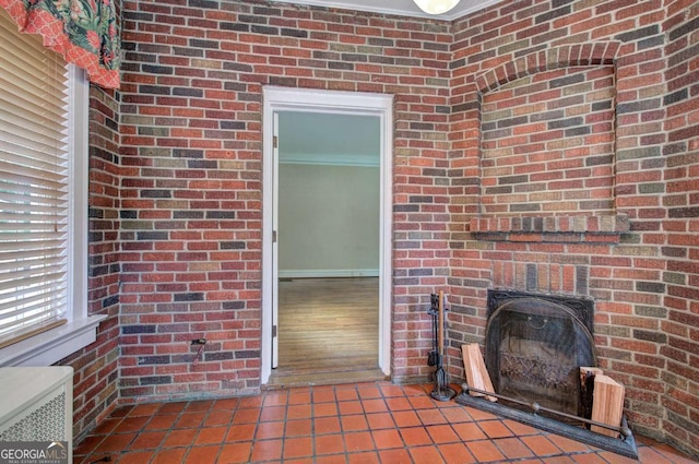 interior space featuring tile patterned flooring, a brick fireplace, and ornamental molding