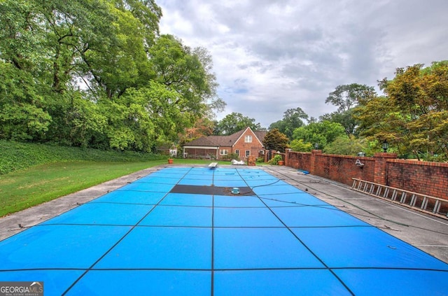 view of swimming pool featuring a patio and a lawn