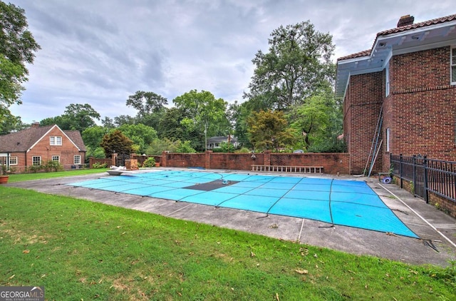 view of pool with a lawn