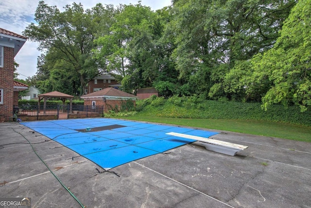 view of swimming pool featuring a gazebo, a diving board, and a patio area