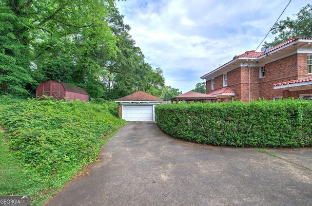 view of yard featuring a garage and a storage unit