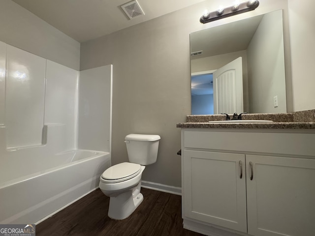 full bathroom featuring hardwood / wood-style flooring, vanity, shower / bath combination, and toilet