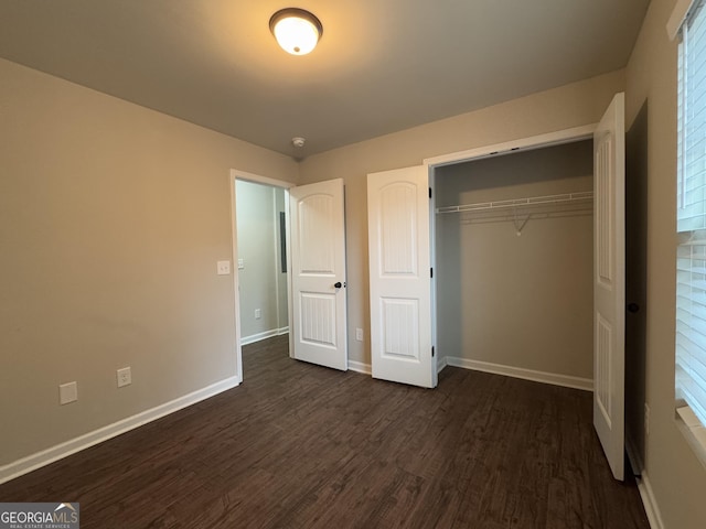 unfurnished bedroom featuring dark wood-type flooring and a closet