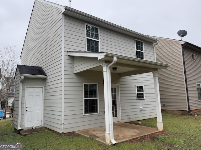 back of property with a patio and a yard