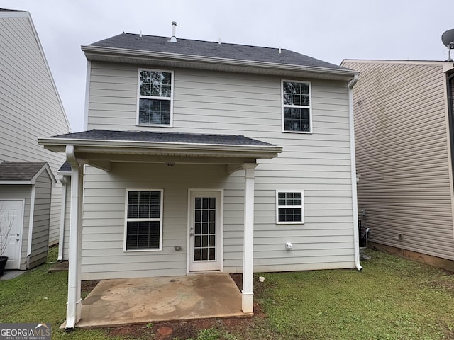 rear view of property featuring a yard and a patio area