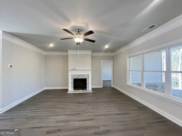 unfurnished living room featuring baseboards, visible vents, dark wood finished floors, ornamental molding, and a high end fireplace