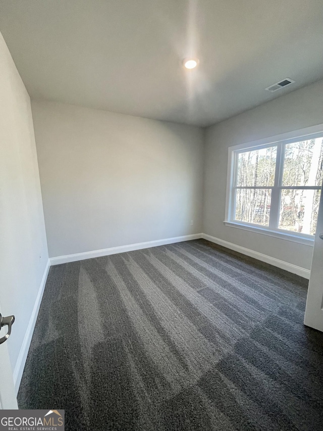 spare room with baseboards, visible vents, dark carpet, and recessed lighting