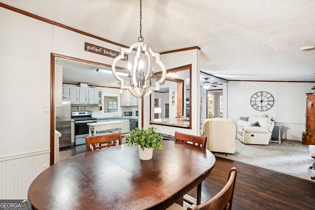 dining space featuring ceiling fan with notable chandelier, ornamental molding, hardwood / wood-style floors, and a textured ceiling