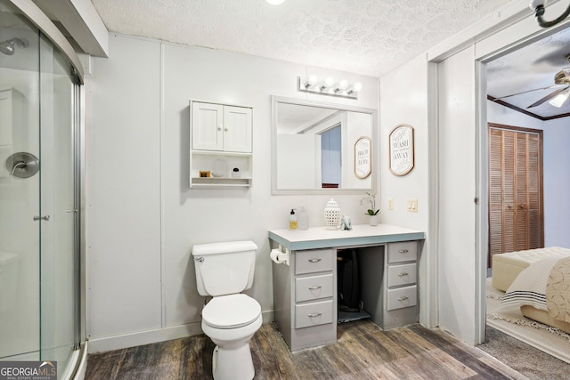 bathroom with a shower with shower door, a textured ceiling, vanity, ceiling fan, and hardwood / wood-style floors