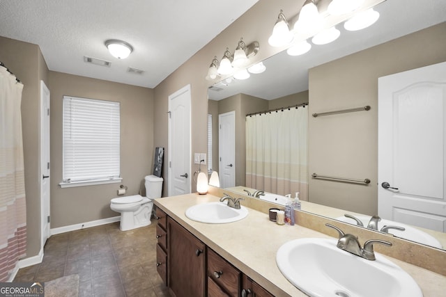 bathroom with vanity, toilet, tile patterned flooring, and a textured ceiling