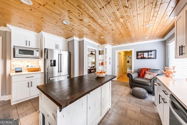 kitchen featuring wood ceiling, white cabinetry, stainless steel appliances, ornamental molding, and a kitchen island