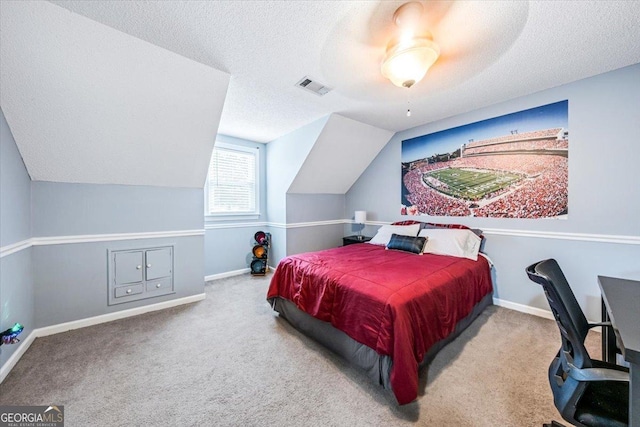 carpeted bedroom with ceiling fan, vaulted ceiling, and a textured ceiling