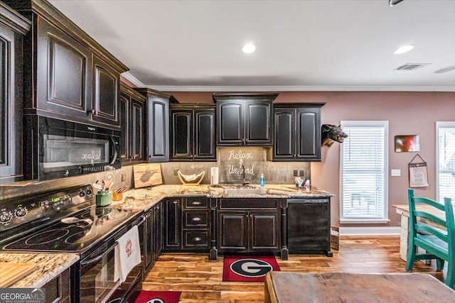 kitchen with ornamental molding, backsplash, light hardwood / wood-style floors, and black appliances