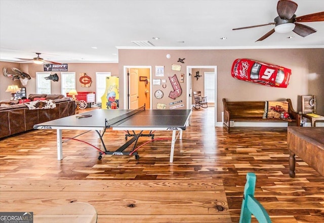 playroom featuring crown molding, wood-type flooring, and ceiling fan