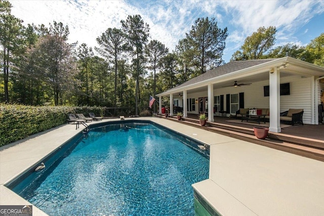 view of swimming pool featuring ceiling fan and a deck