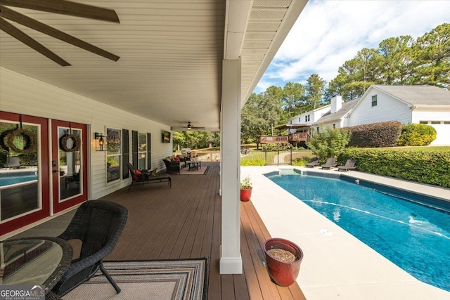 view of swimming pool featuring a wooden deck and ceiling fan