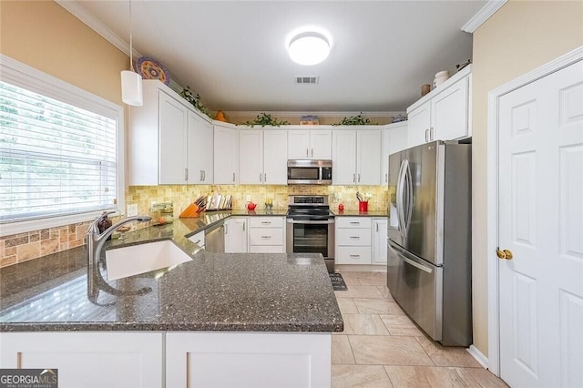 kitchen with white cabinetry, sink, stainless steel appliances, and kitchen peninsula